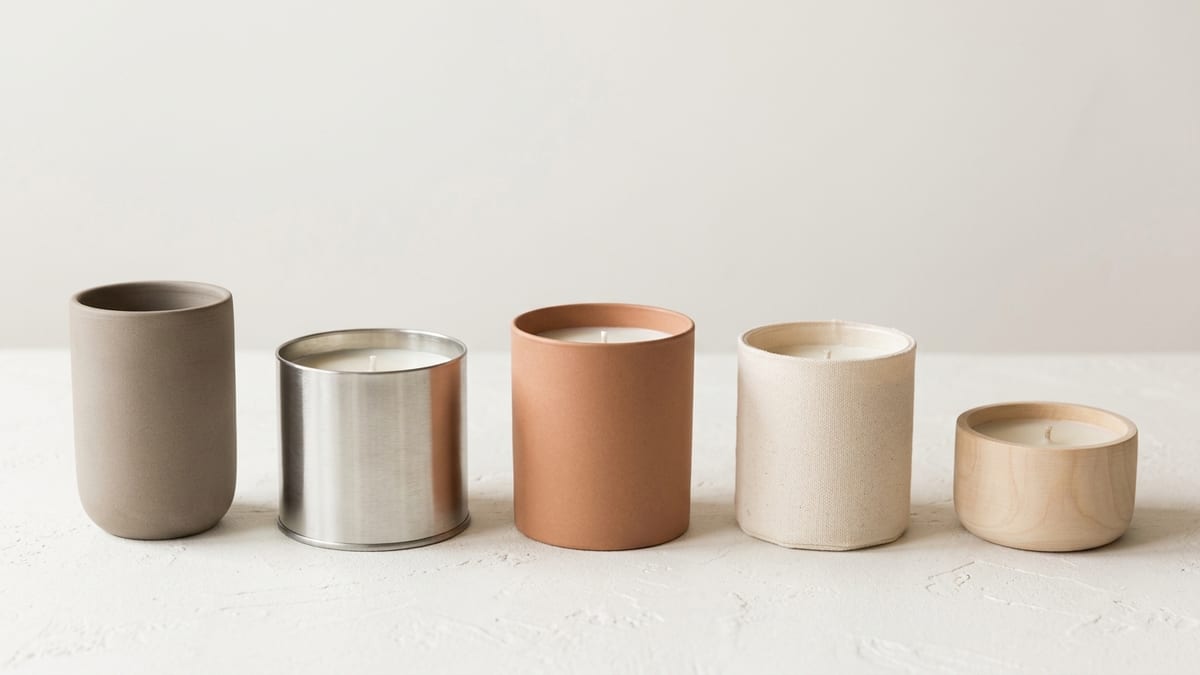 Several unlabeled candle vessels of different sizes arranged in a row for comparison